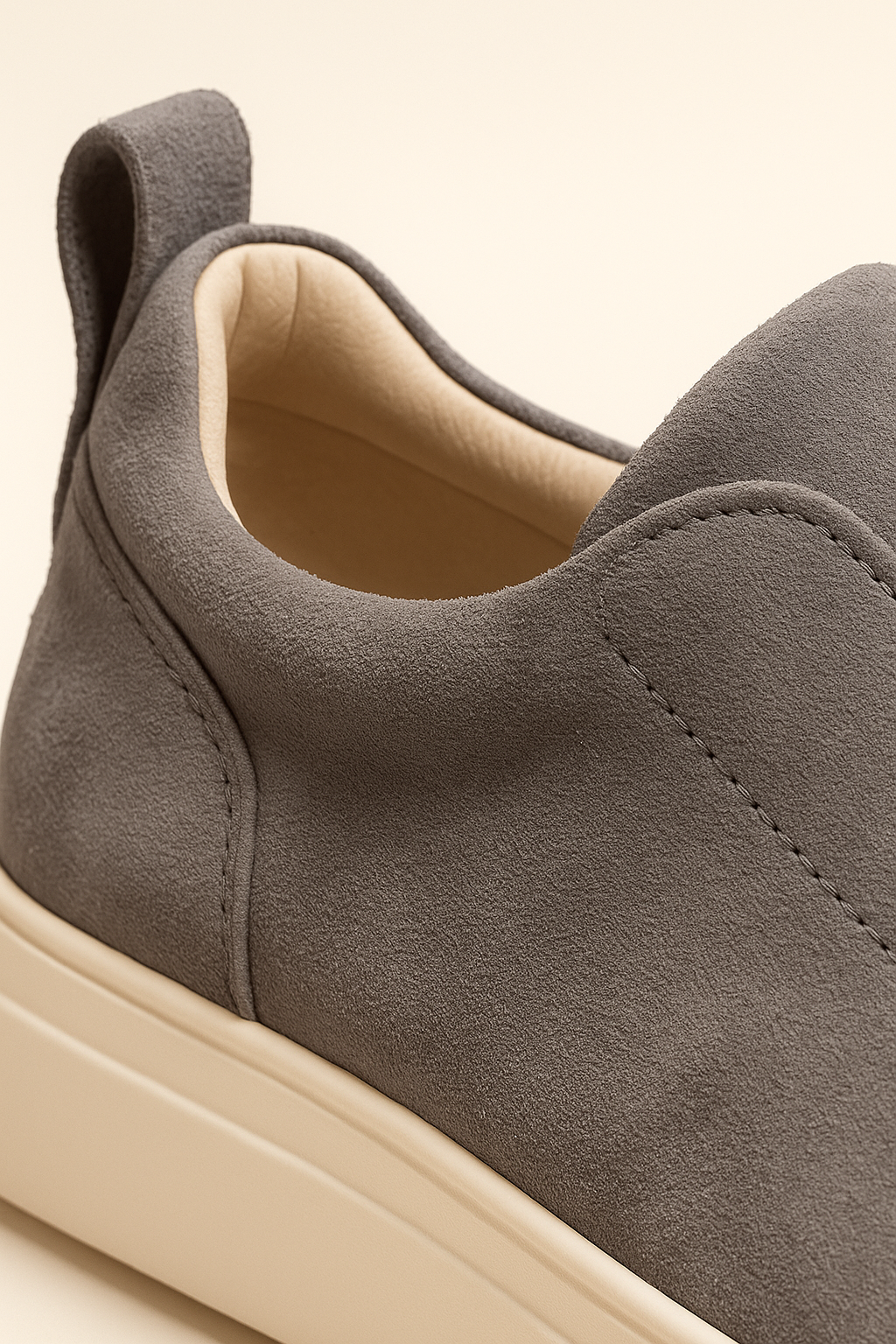 Close-up of Emiral Couture grey suede slip-on sneakers with a sleek design and comfortable fit.