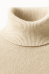 Emiral Couture ivory cashmere turtleneck sweater, showcasing a soft texture and elegant design.